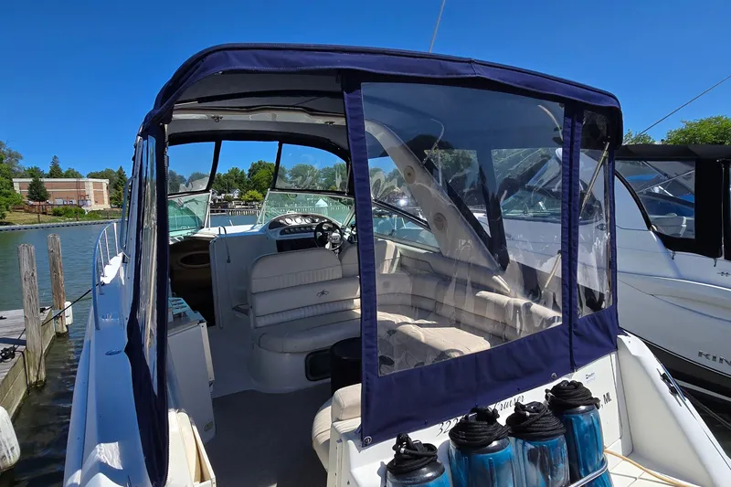 Slide: The Image of 2001 Monterey 322 Cruiser boat docked, featuring a covered cockpit and plush seating. - 5