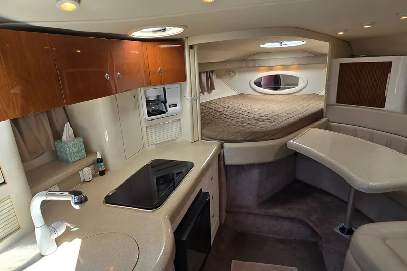 Slide: The Image of Interior of a 2001 Monterey 322 Cruiser featuring a cozy cabin with kitchenette and bed. - 17