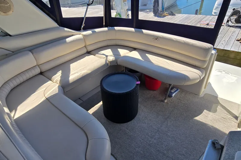 Slide: The Image of Luxurious seating area on a 2001 Monterey 322 Cruiser yacht, featuring beige leather upholstery. - 8