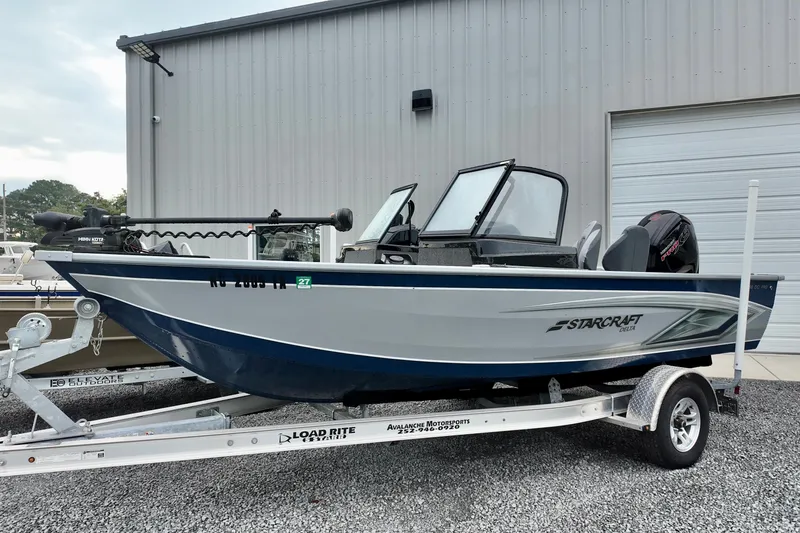 The Image of 2023 Starcraft Delta 188 DC Pro boat on trailer, parked outside a building. - 1