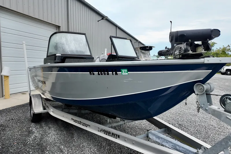 Slide: The Image of 2023 Starcraft Delta 188 DC Pro boat on trailer, parked outside a metal building. - 9