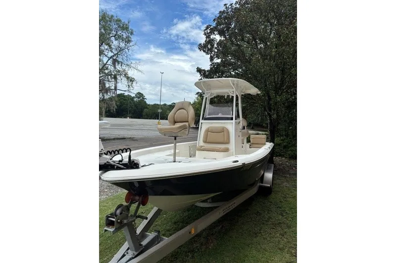 Slide: The Image of 2017 Nautistar 227 XTS boat on trailer, parked outdoors with trees in background. - 9