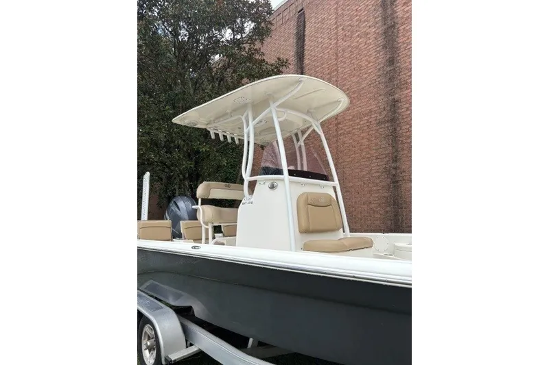 Slide: The Image of 2017 Nautistar 227 XTS boat with T-top and beige seating, parked on a trailer. - 6