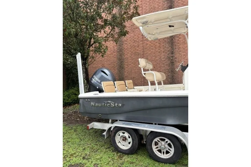 Slide: The Image of 2017 Nautistar 227 XTS boat on trailer, parked near brick wall. - 7