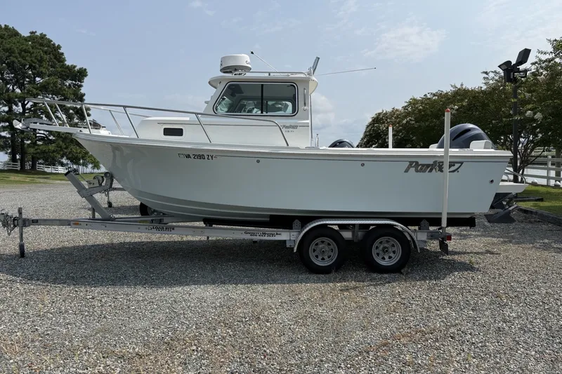 Slide: The Image of 2021 Parker 2120 Sport Cabin boat on trailer, parked outdoors. - 11