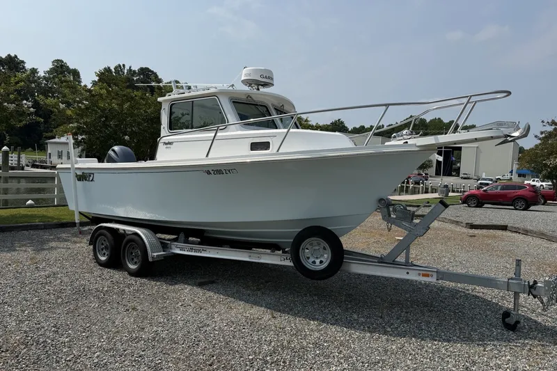 The Image of 2021 Parker 2120 Sport Cabin boat on trailer, parked outdoors. - 1