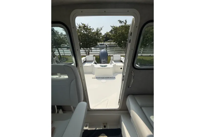 Slide: The Image of Interior view of a 2021 Parker 2120 Sport Cabin boat, showing seating and outdoor access. - 7