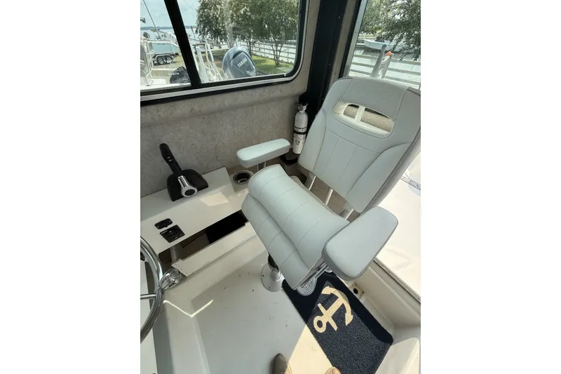 Slide: The Image of Captain's chair in 2021 Parker 2120 Sport Cabin boat interior, featuring steering controls. - 8