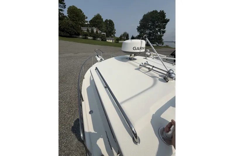 Slide: The Image of 2021 Parker 2120 Sport Cabin boat with Garmin radar, docked near trees and houses. - 9