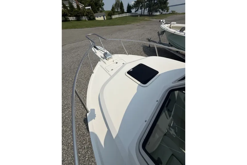 Slide: The Image of Parker 2120 Sport Cabin 2021 boat on gravel near waterfront homes. - 10