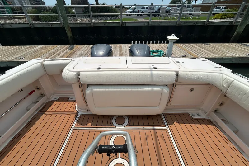 Slide: The Image of 2005 Grady-White Express 330 boat interior with cushioned seating and wooden deck. - 2
