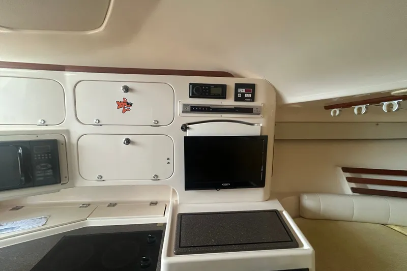 Slide: The Image of 2005 Grady-White Express 330 cabin interior with storage, microwave, and TV. - 15