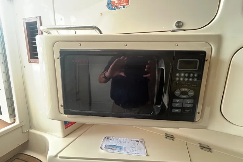 Slide: The Image of Microwave inside 2005 Grady-White Express 330 boat cabin, reflecting interior details. - 19