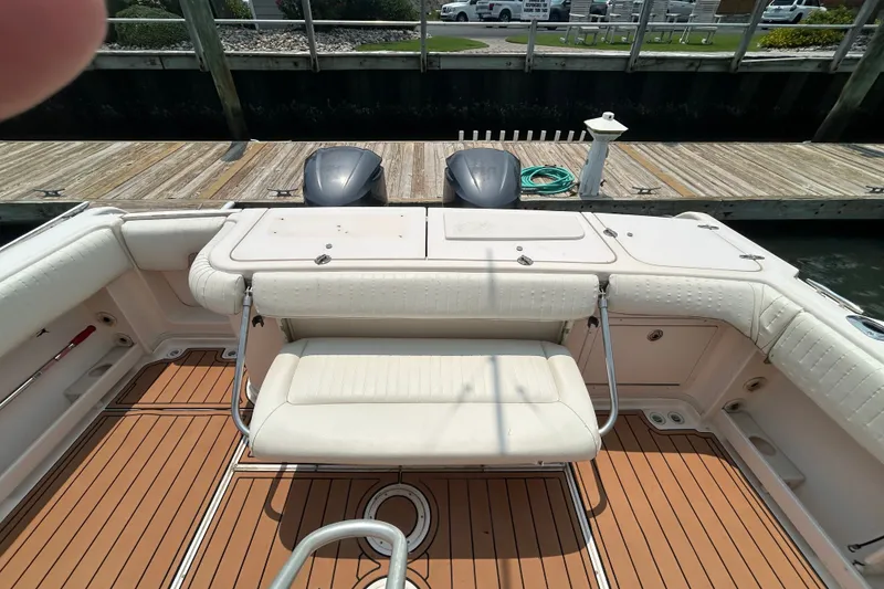 Slide: The Image of 2005 Grady-White Express 330 boat interior with seating and twin engines at dock. - 4