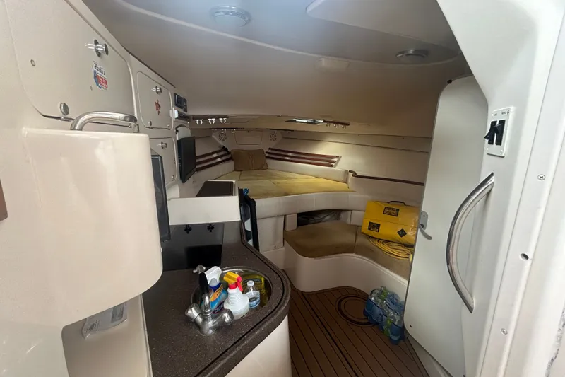Slide: The Image of Interior of 2005 Grady-White Express 330 boat, featuring cozy cabin and kitchenette. - 13