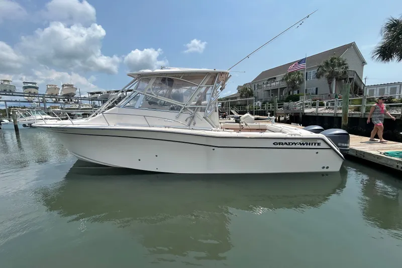 The Image of 2005 Grady-White Express 330 boat docked in a marina under a partly cloudy sky. - 0