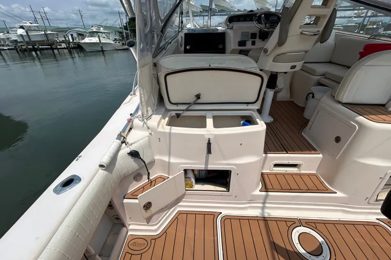 Slide: The Image of 2005 Grady-White Express 330 boat interior with open storage compartments and teak flooring. - 7