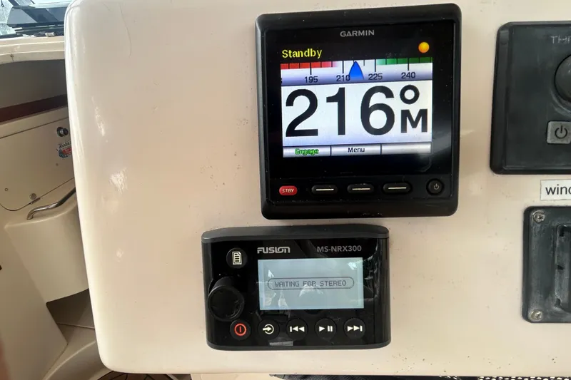 Slide: The Image of Control panel of a 2005 Grady-White Express 330 boat with Garmin and Fusion displays. - 32