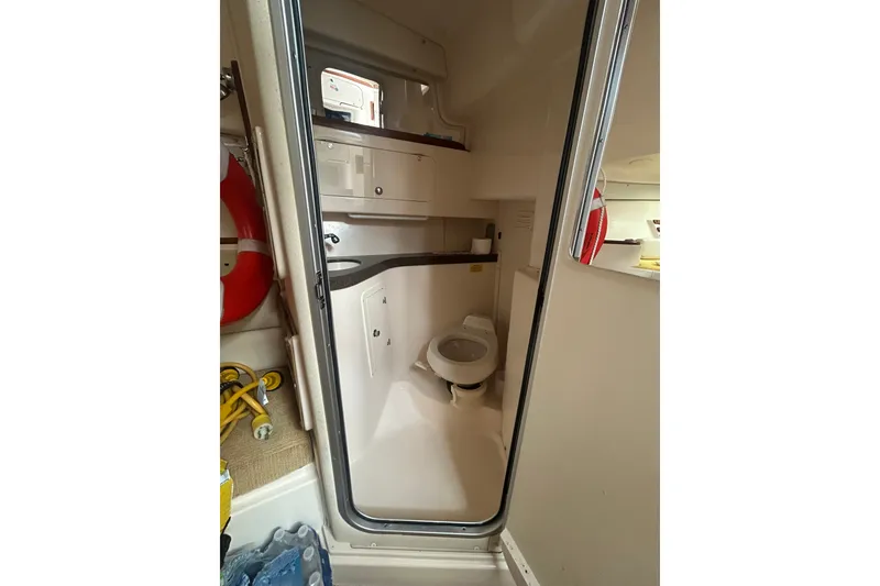 Slide: The Image of 2005 Grady-White Express 330 boat bathroom interior with toilet and storage. - 26