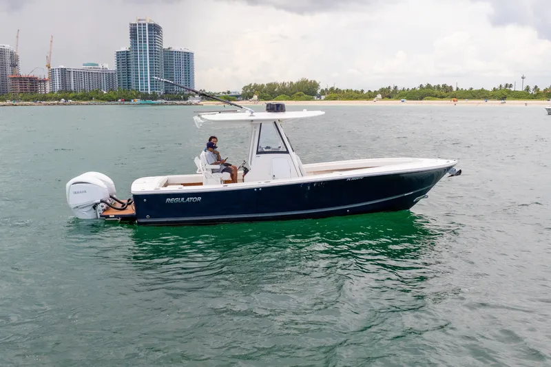 Slide: The Image of 2023 Regulator 28 Forward Seating boat on water near city skyline. - 13