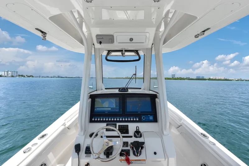 Slide: The Image of 2023 Regulator 28 Forward Seating boat dashboard with dual screens on calm water. - 16