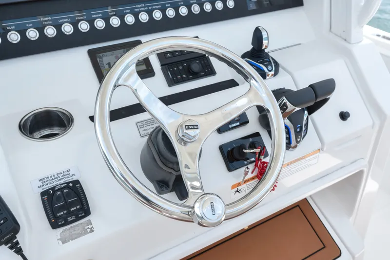 Slide: The Image of Control panel of 2023 Regulator 28 Forward Seating boat with steering wheel and controls. - 21