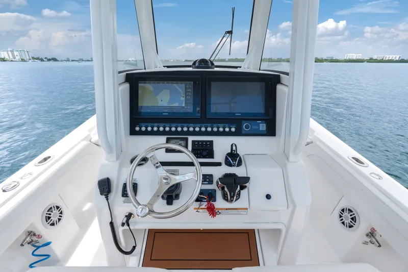 Slide: The Image of 2023 Regulator 28 Forward Seating boat helm with advanced navigation displays on open water. - 17