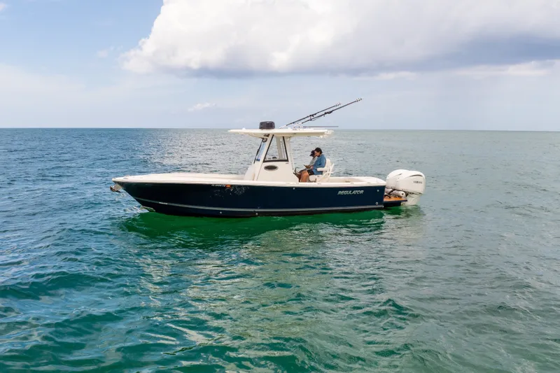 Slide: The Image of 2023 Regulator 28 Forward Seating boat on open water, featuring dual Yamaha engines. - 11