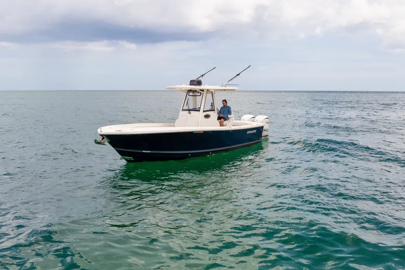 Slide: The Image of 2023 Regulator 28 Forward Seating boat on open water, under cloudy sky. - 12