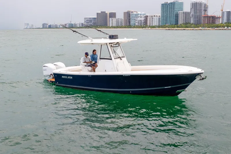The Image of 2023 Regulator 28 Forward Seating boat cruising near city skyline. - 0