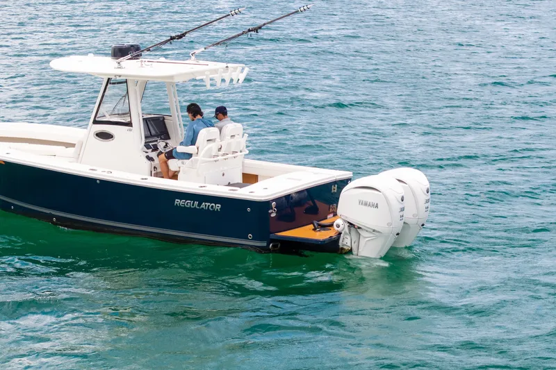 Slide: The Image of 2023 Regulator 28 Forward Seating boat with dual Yamaha engines on open water. - 9