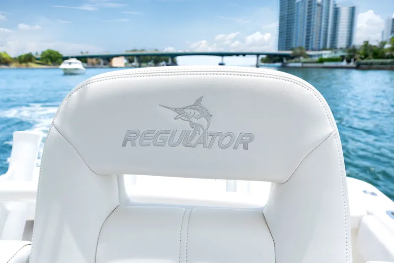 Slide: The Image of 2023 Regulator 28 Forward Seating boat with logo, cruising on a sunny waterway. - 30