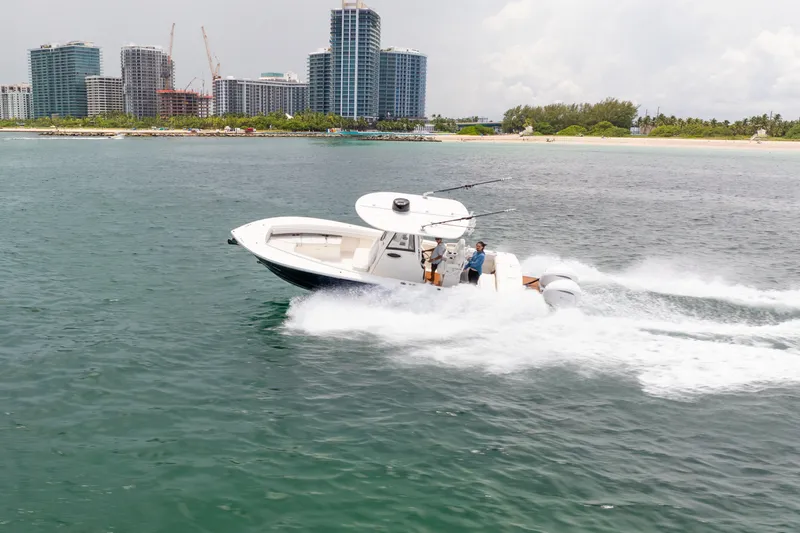 Slide: The Image of 2023 Regulator 28 Forward Seating boat cruising near city skyline. - 3