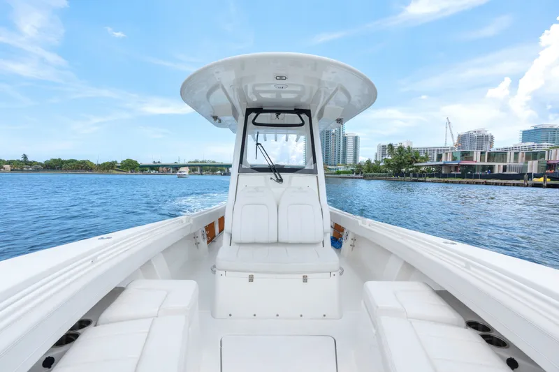 Slide: The Image of 2023 Regulator 28 Forward Seating boat on calm water, cityscape in background. - 33