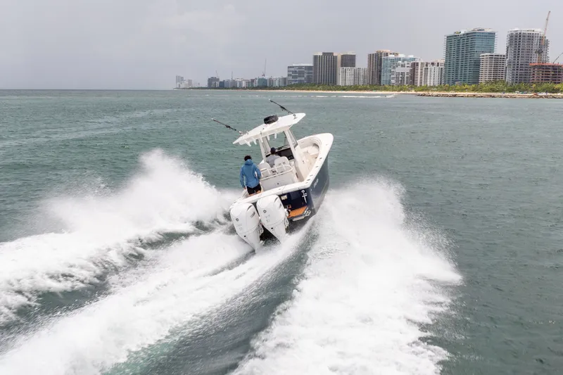 Slide: The Image of 2023 Regulator 28 Forward Seating boat cruising near city skyline. - 4