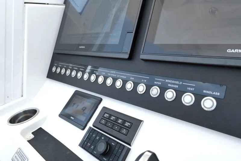 Slide: The Image of 2023 Regulator 28 Forward Seating boat dashboard with Garmin displays and control panel. - 27