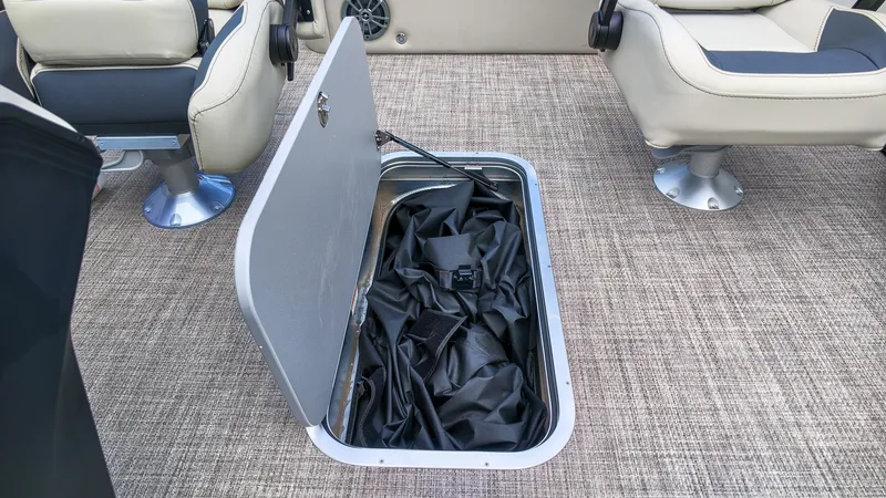 Slide: The Image of An open storage compartment in a boat's floor with a black item inside. - 15