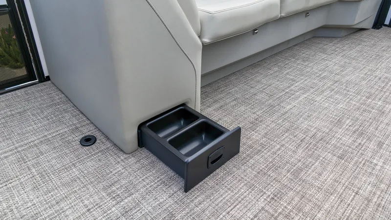 Slide: The Image of A gray seating area with a pull-out black compartment on a textured floor. - 14