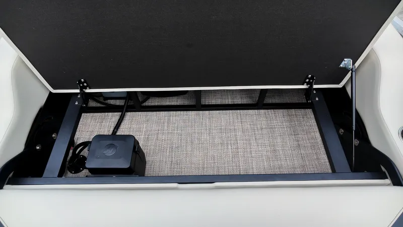 Slide: The Image of Storage compartment under a bench seat with carpeted floor and electronic box. - 11
