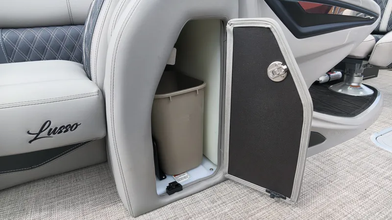 Slide: The Image of An open storage compartment on a Barletta Lusso 25UE boat reveals a trash bin. - 27