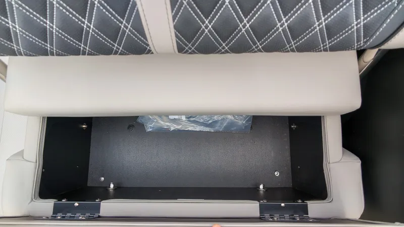 Slide: The Image of A storage compartment beneath a cushioned seat with a black base and silver hinges. - 21