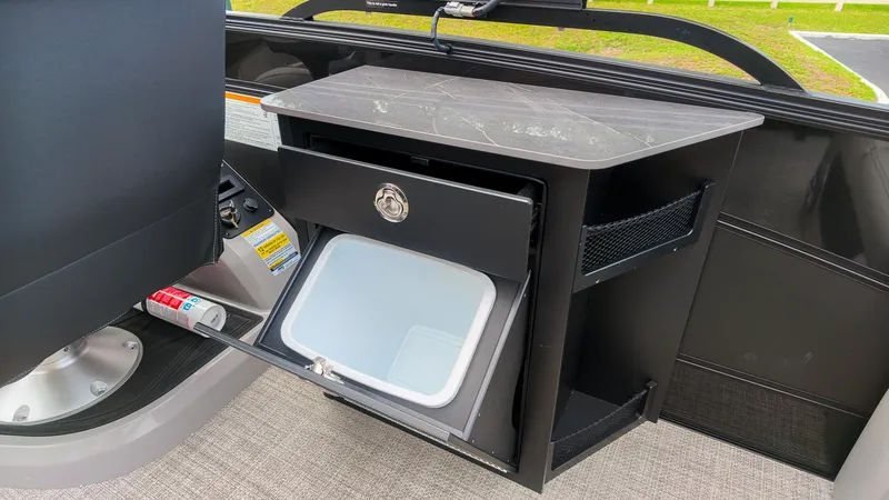 Slide: The Image of The 2027 Barletta Lusso 25UE features a sleek storage area with a fold-out compartment. - 17