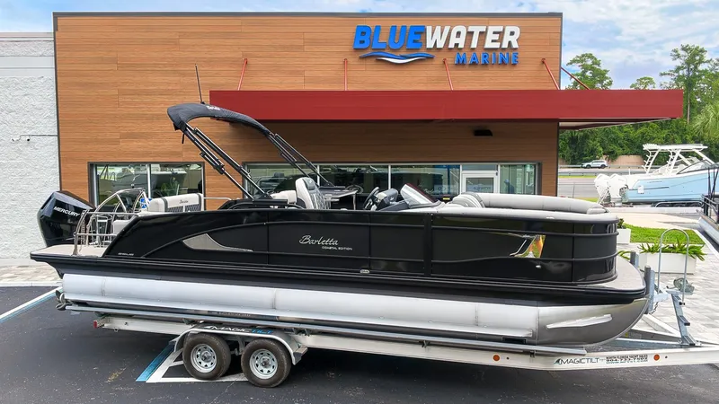 The Image of A sleek black pontoon boat on a trailer in front of a modern building. - 1