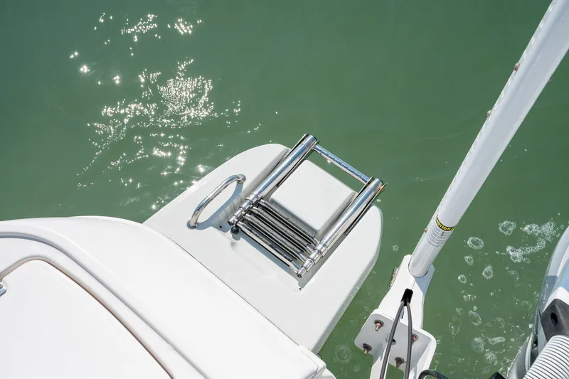 Slide: The Image of 2025 Caymas 26 HB boat with a stainless steel swim ladder on calm water. - 20