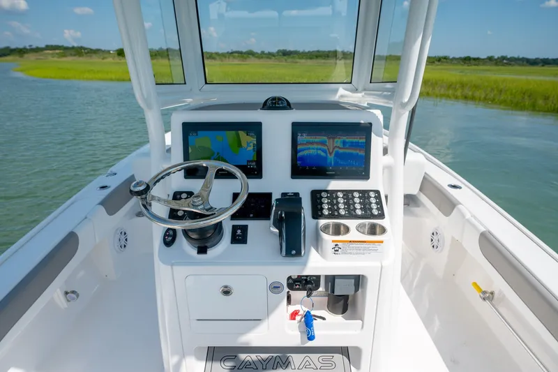Slide: The Image of 2025 Caymas 26 HB boat dashboard with steering wheel and navigation screens. - 13