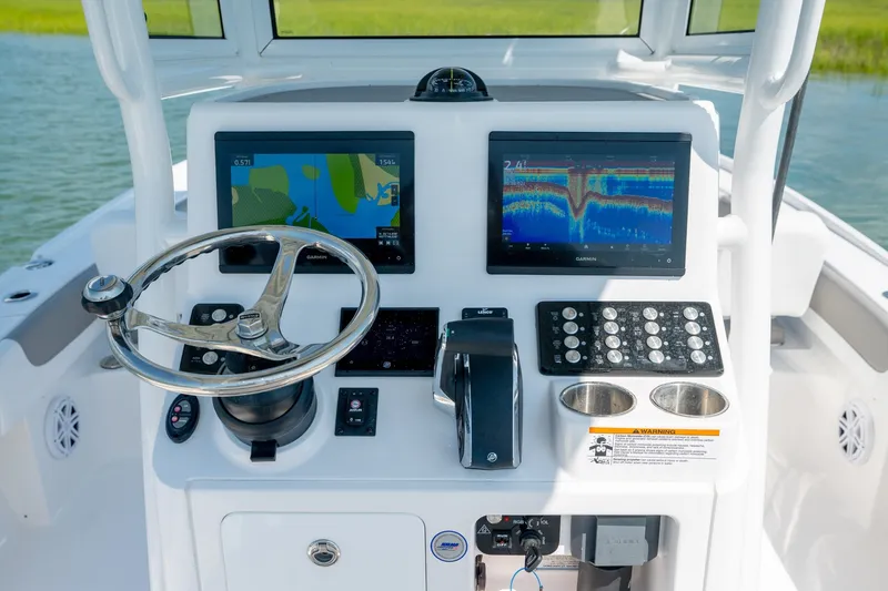 Slide: The Image of 2025 Caymas 26 HB boat dashboard with dual Garmin displays and steering wheel. - 14