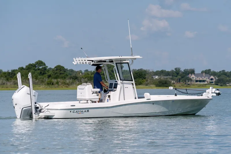 The Image of 2025 Caymas 26 HB boat cruising on a calm lake with scenic background. - 0