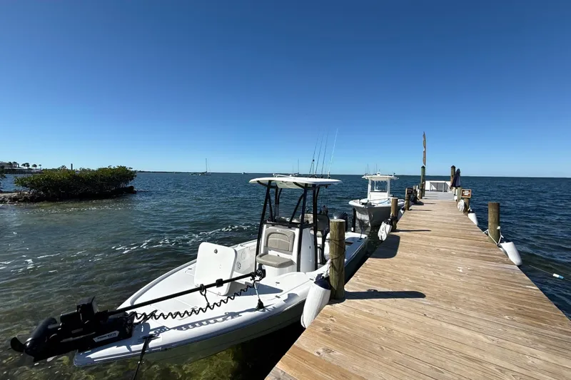 Slide: The Image of 2025 Sea Hunt BX22BR boat docked by a wooden pier on a sunny day. - 4