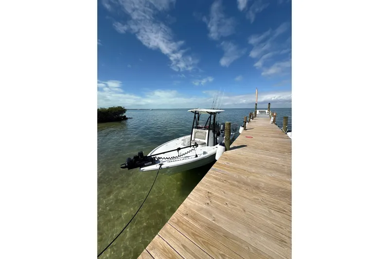 Slide: The Image of Boat docked by wooden pier, Sea Hunt BX22BR 2025 model, under clear blue sky. - 5