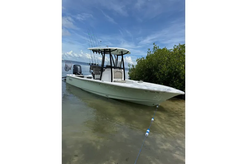 Slide: The Image of 2025 Sea Hunt BX22BR boat anchored near shoreline with fishing rods and clear sky. - 1